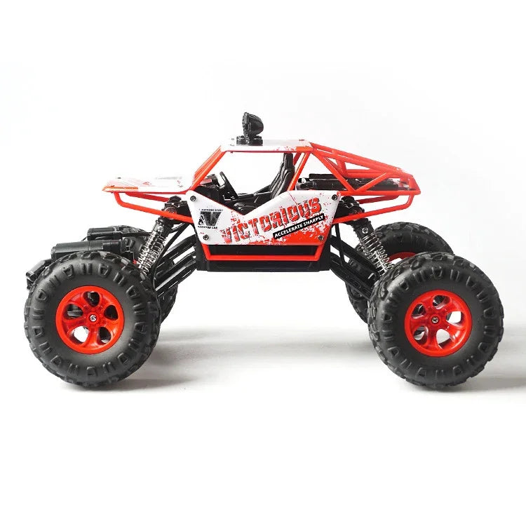 Red and white remote control off-road truck with large tires on a white background